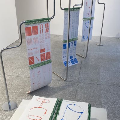 Drawings of two glasses on paper in the gallery