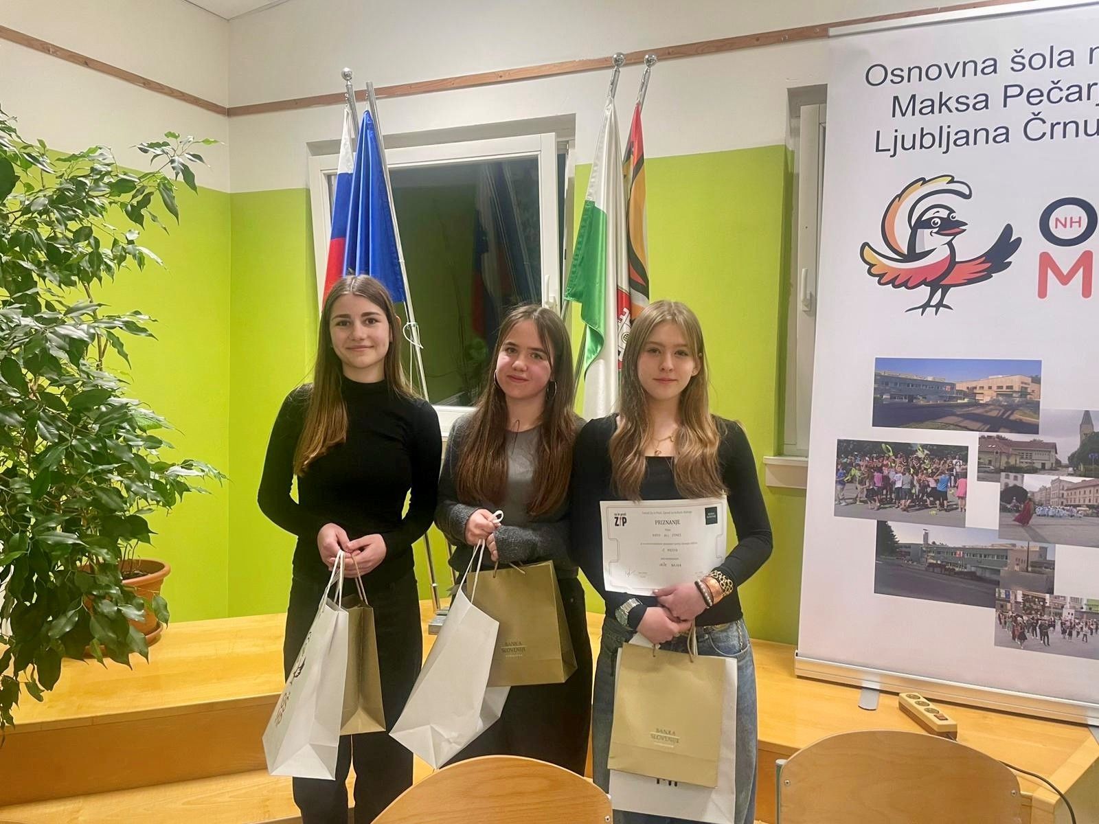 Skupinska slika zmagovalcev izkušenih debaterjev v kategoriji izkušeni iz osnovne šole; na sliki so tri deklice, ki v roki držijo priznanja.