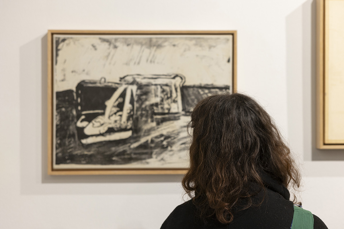 Obiskovalci si ogledujejo razstavljene grafike