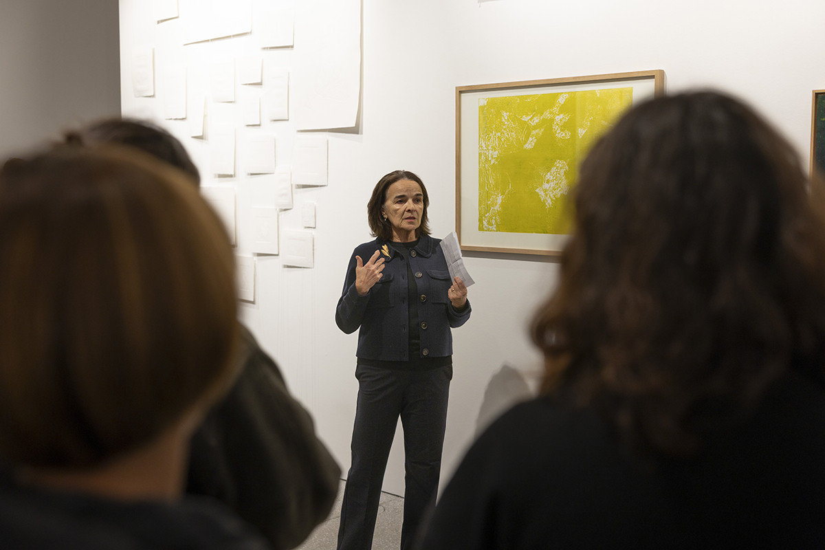 Obiskovalci si ogledujejo razstavljene grafike