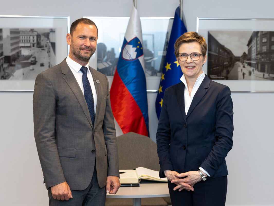 guverner Primož Dolenc in Claudia Buch, predsednica Nadzornega odbora Enotnega mehanizma nadzora stojita pred slovensko in EU zastavo