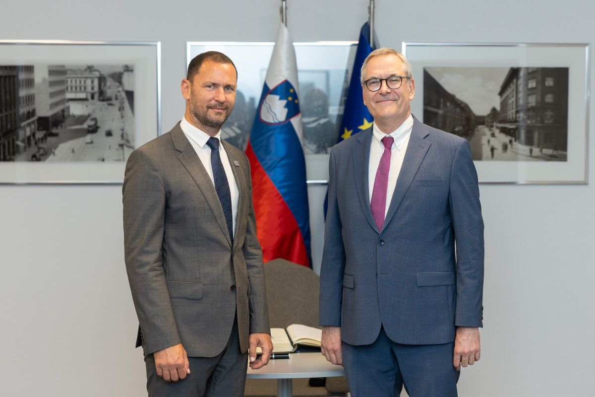 guverner Primož Dolenc in Dominiq Laboureix, predsednik Enotnega odbora za reševanje stojita pred slovensko in EU zastavo