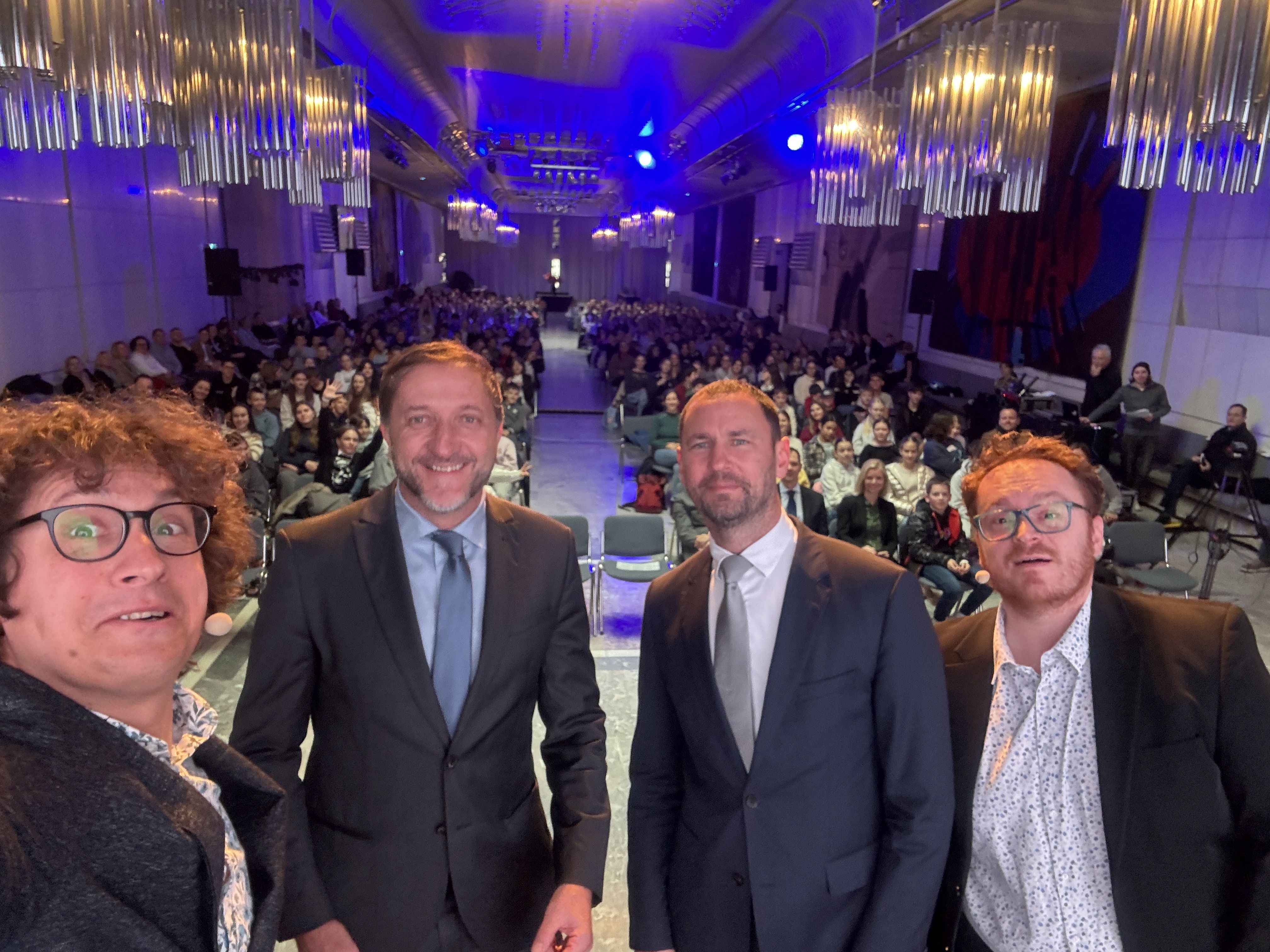 Rok Škrlep, Klemen Boštjančič, Primož Dolenc, Juš Milčinski selfie slika z otroci v ozadju