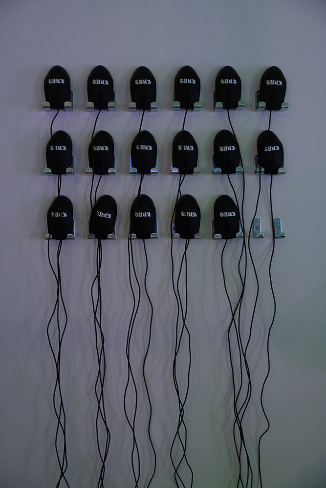 A man is looking at illuminated panels displayed in a gallery.